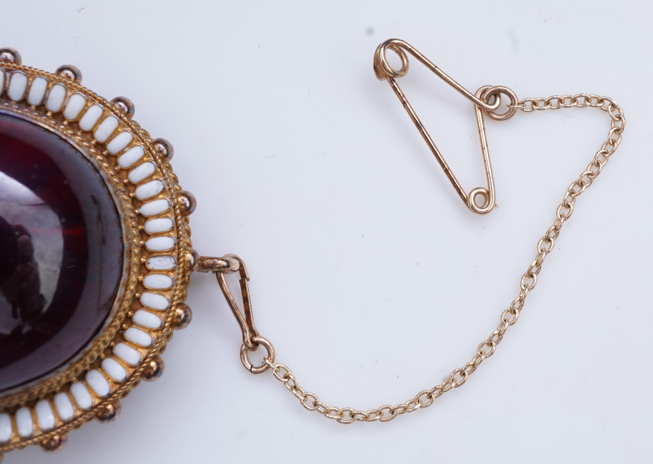 A Victorian garnet and enamel brooch, mid 19th century